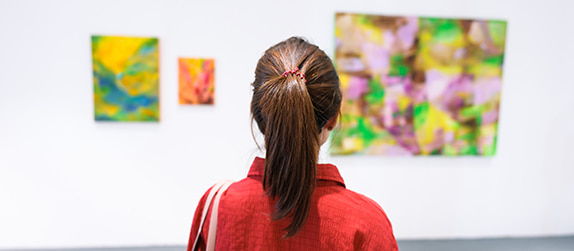 a woman stands in a contemporary art gallery