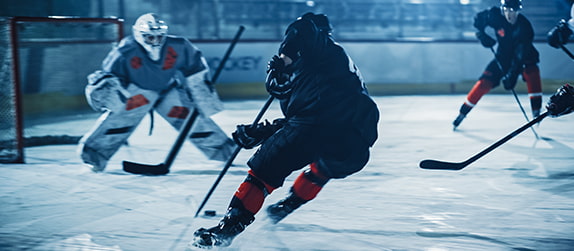 Hockey players advance on an ice rink